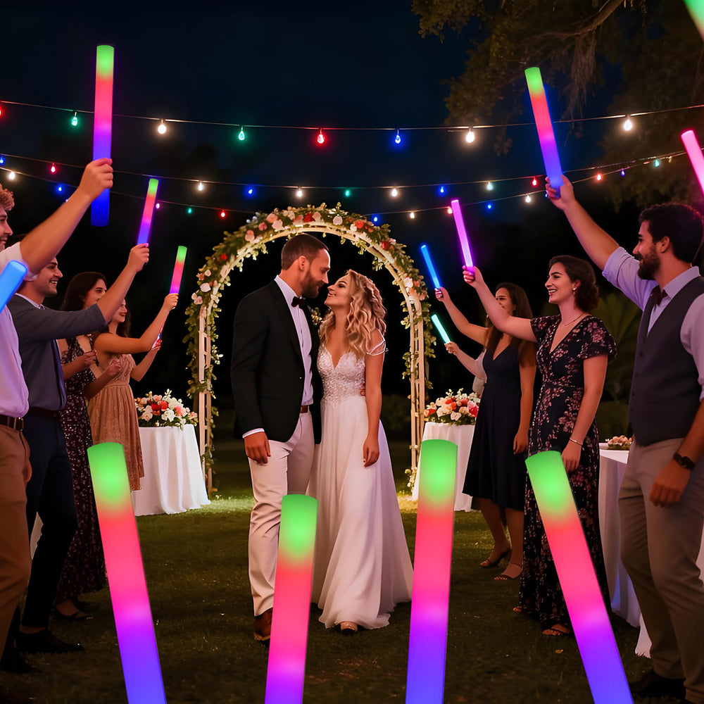 Wedding couple surrounded by guests with colorful LED foam sticks under string lights.
